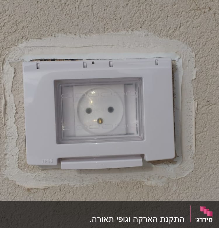 שקע חשמל עם כיסוי פלסטיק שקוף על קיר
